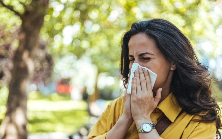 Sneezing woman in a park